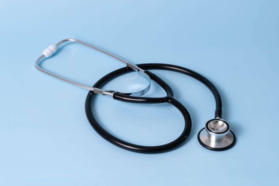 A stethoscope resting on a table with medical equipment