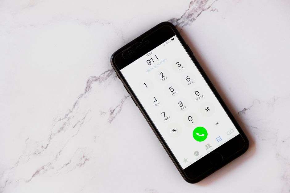 A smartphone screen displaying the number 911 being dialed for an emergency call