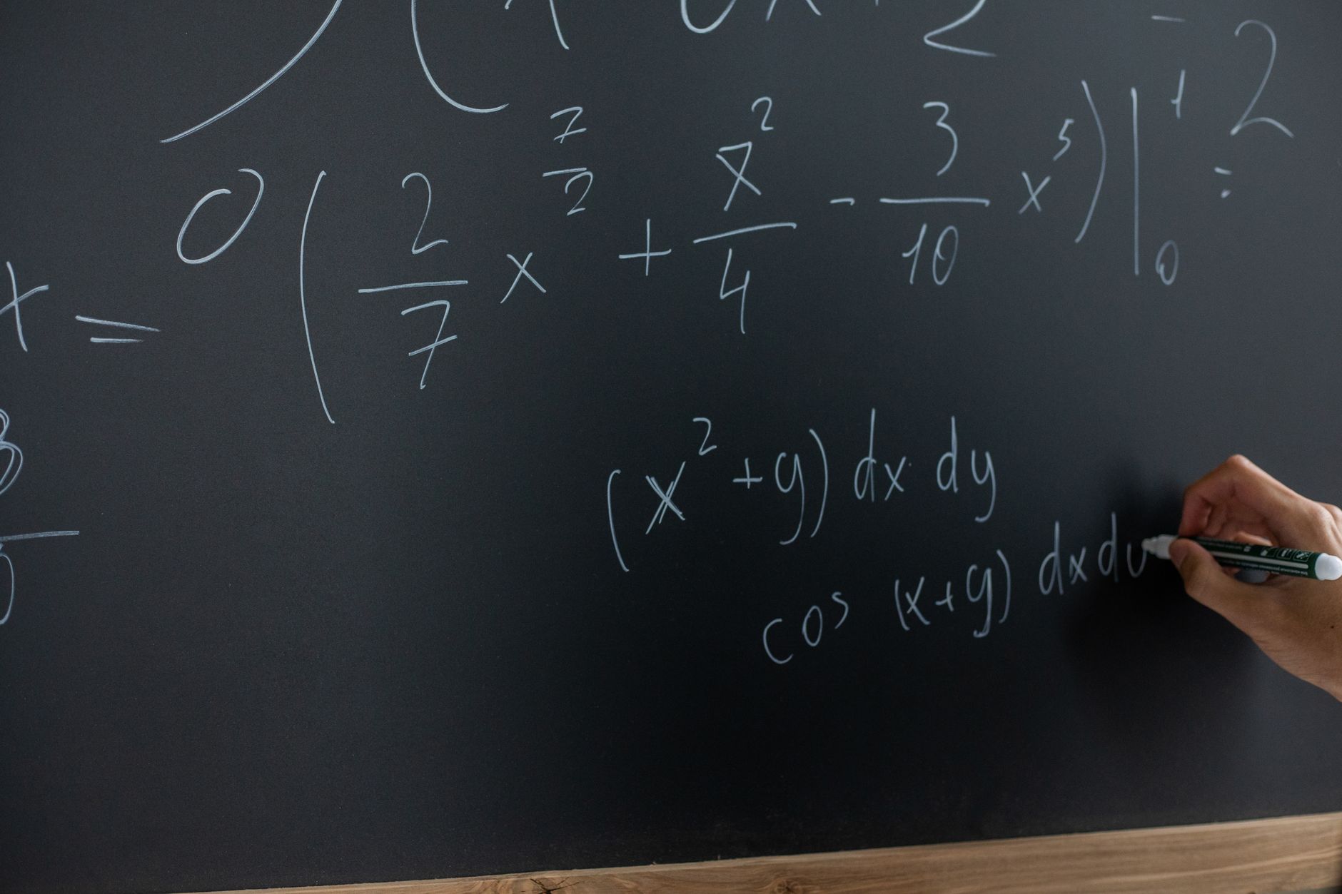 A classroom chalkboard covered in mathematical equations
