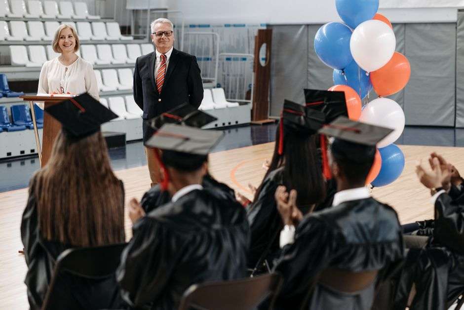 Graduates in caps and gowns seated together during a high school graduation ceremony