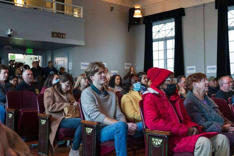 Residents seated in an audience listening to speakers at a public hearing on a coal ash pond closure plan