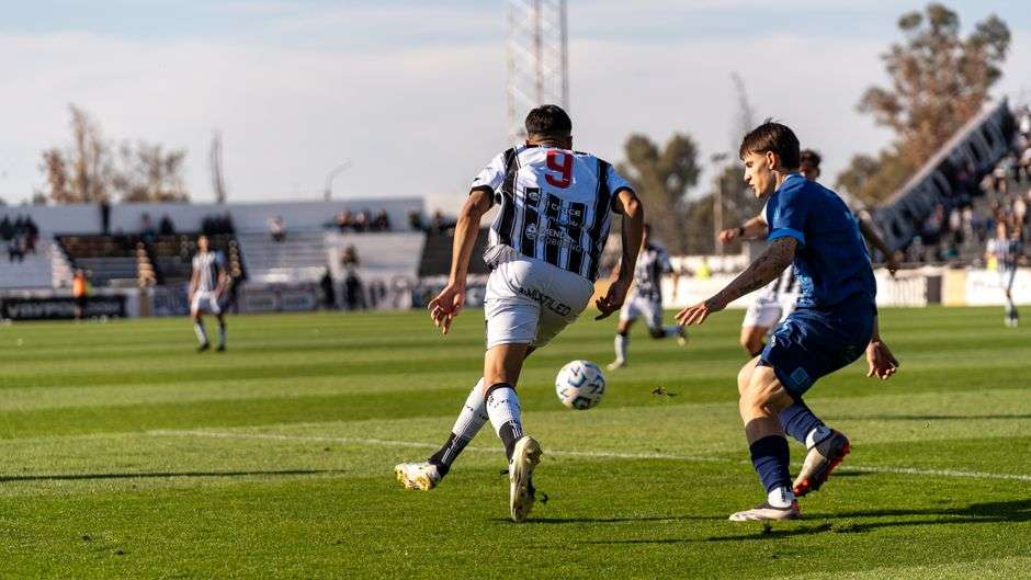 Soccer players compete for the ball during an outdoor match on a grass field