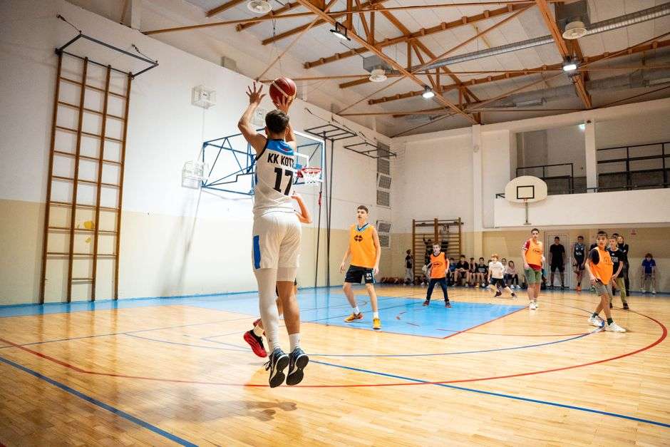 High school basketball players compete during a playoff game on an indoor court