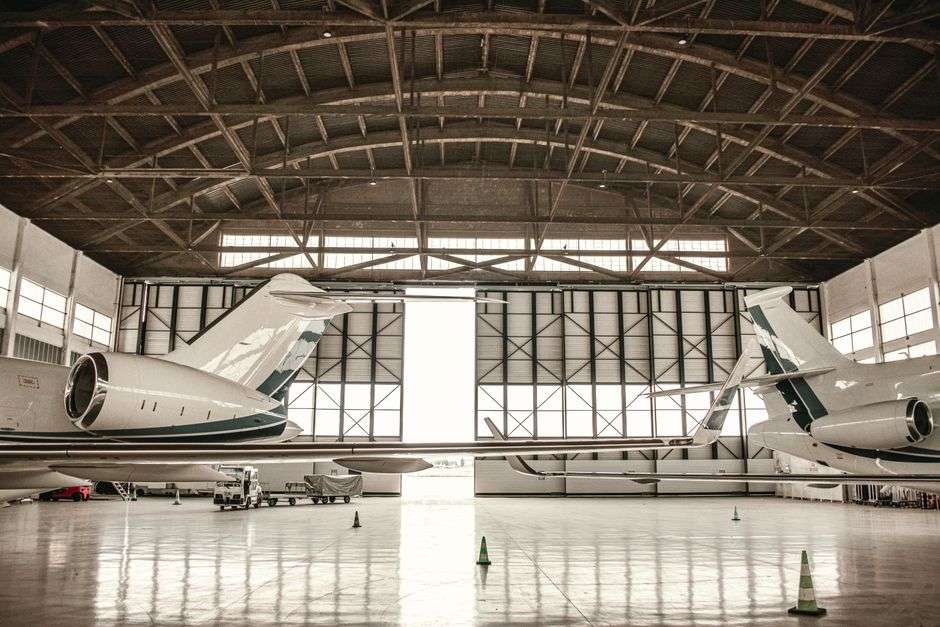 Commercial jets parked inside a large aircraft assembly hangar