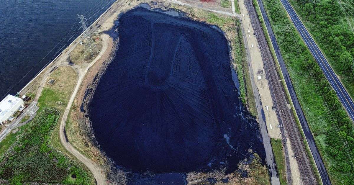 Aerial view of a coal ash storage pond beside a river, illustrating concerns about Alabama coal ash oversight