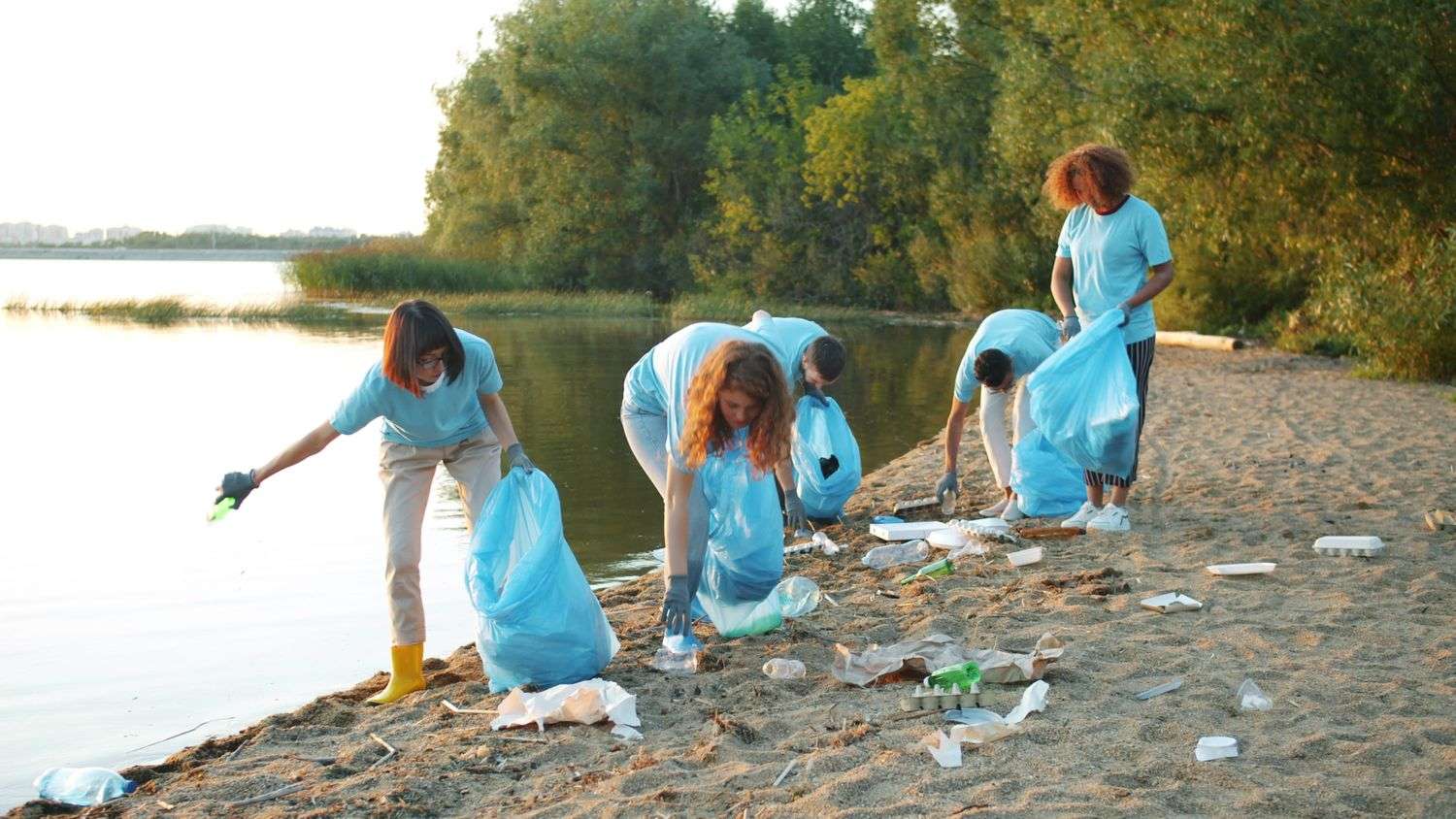 Volunteers picking up litter and debris along a sandy Alabama coastline