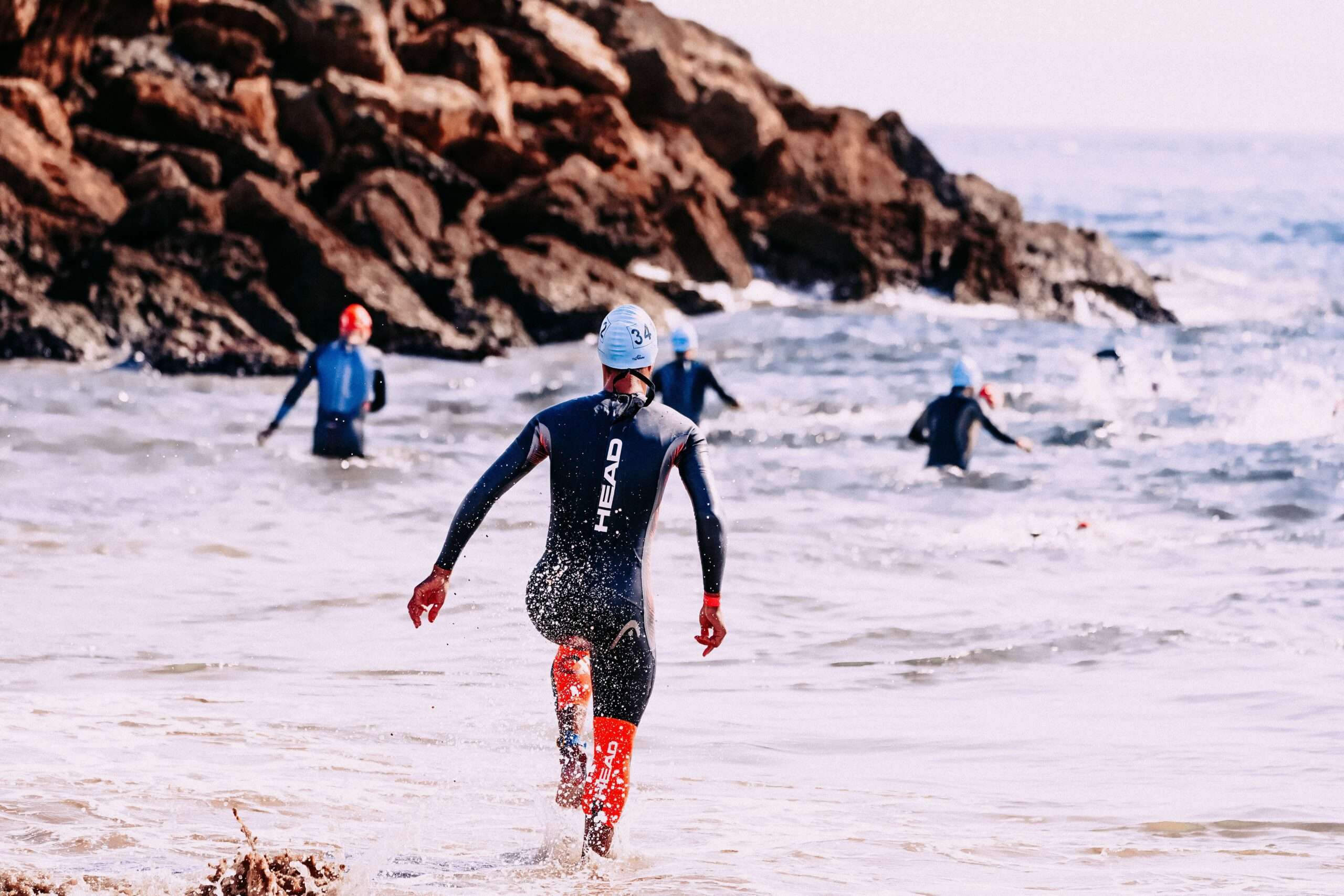 Athletes swimming in the Gulf during a coastal triathlon event