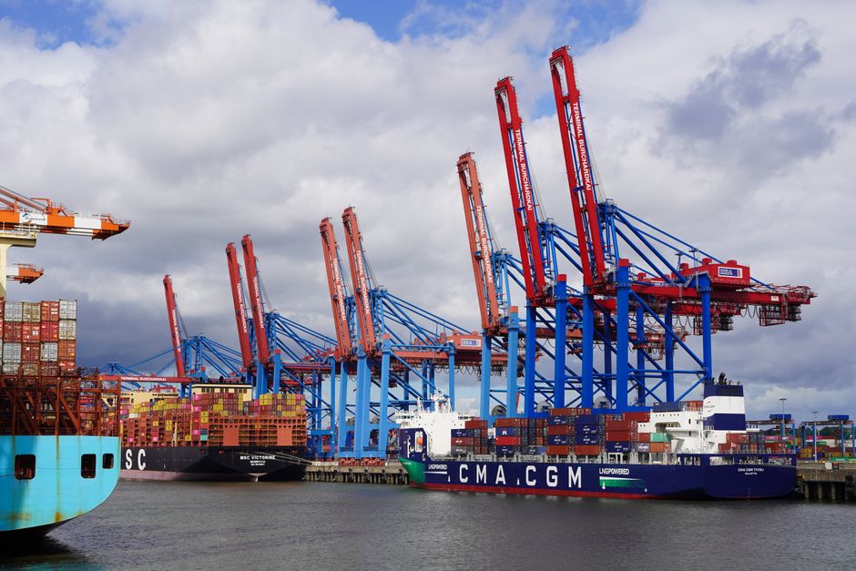 A cargo ship docked at a port facility similar to the Alabama State Docks