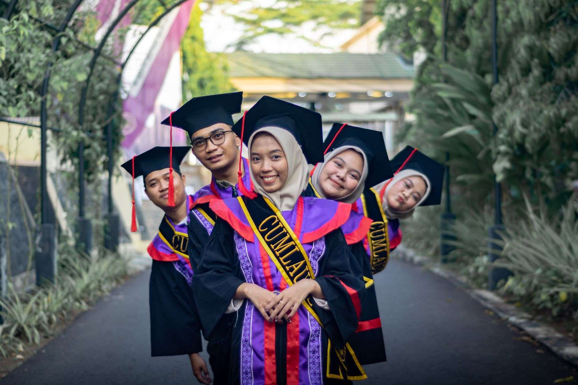 College graduates celebrating outdoors in caps and gowns
