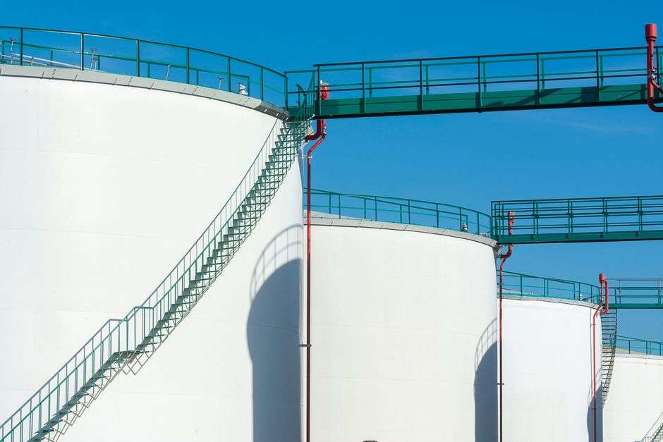 Large above-ground industrial storage tanks used to hold chemicals at a waterfront terminal