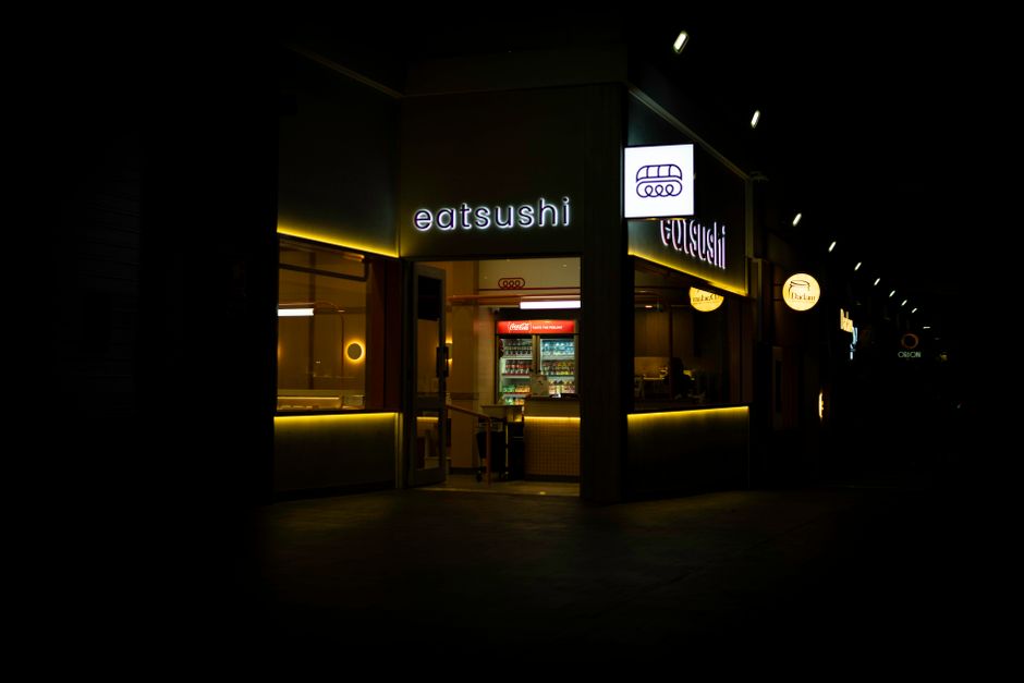 Exterior of a small restaurant storefront lit at night
