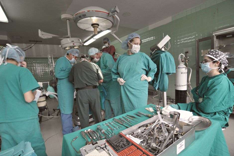Army surgical team members work together during a medical procedure