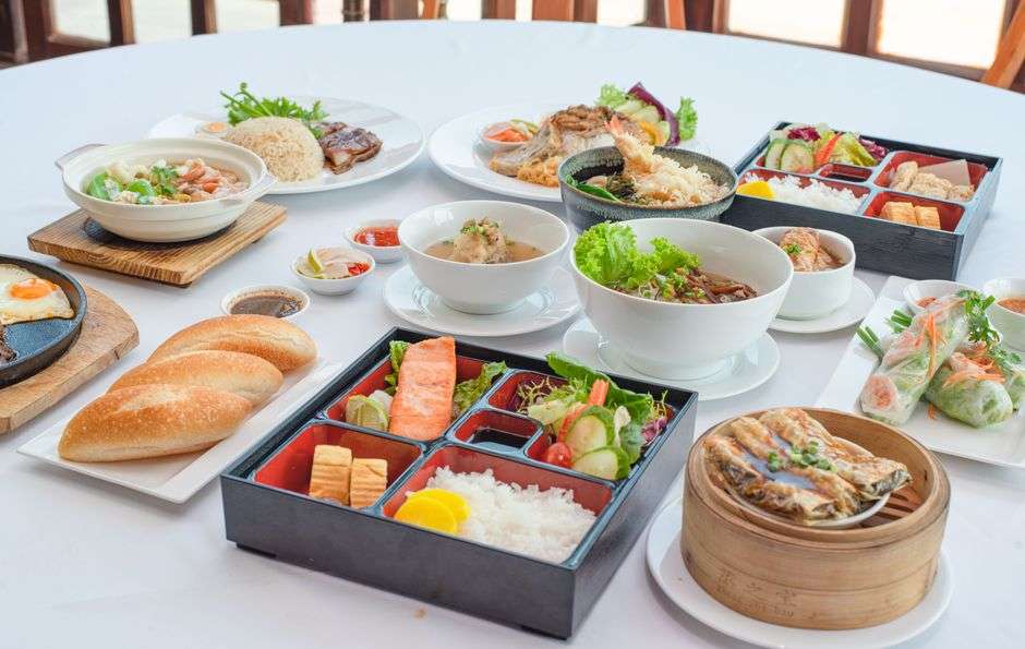 Bowls and boxes of assorted Asian fusion dishes arranged on a table