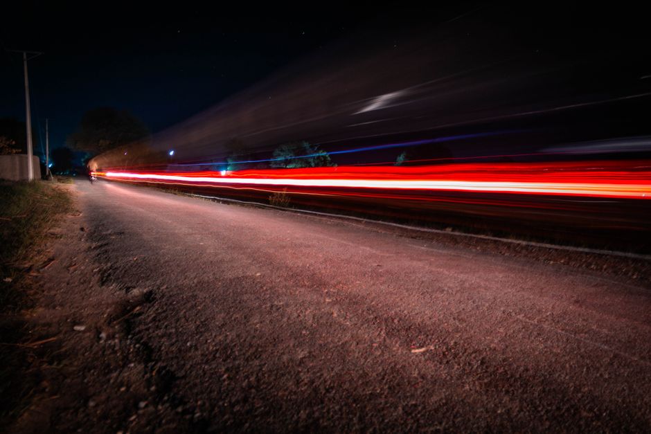 Two-lane rural highway stretching into the distance at night
