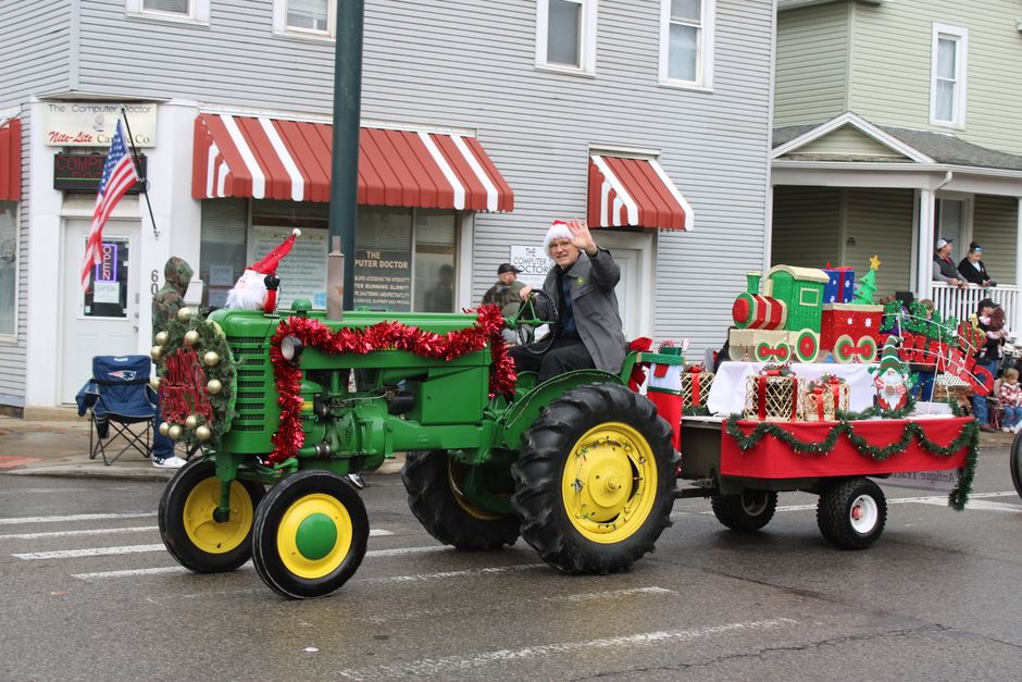 Christmas parade with festive floats moving down a small town street