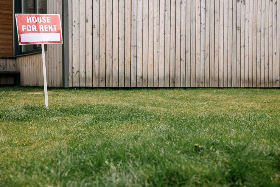 A house for rent sign in a yard, representing rental housing in Baldwin County
