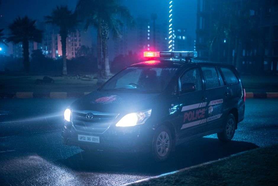 A sheriff patrol car parked on a roadside at night with lights on