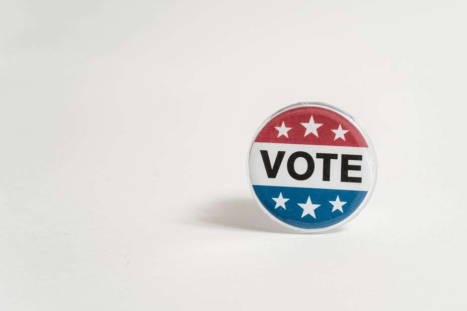 A close-up of a red, white and blue vote button