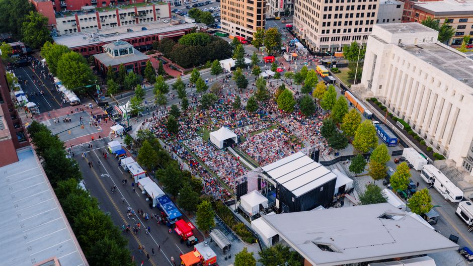 Concertgoers gathered at an outdoor music festival in a downtown setting
