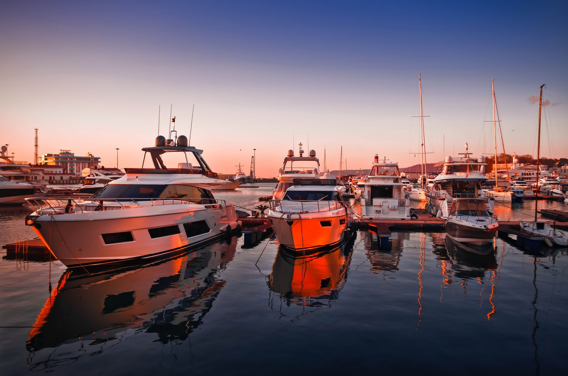 Boats moored at a waterfront yacht basin on a sunny afternoon