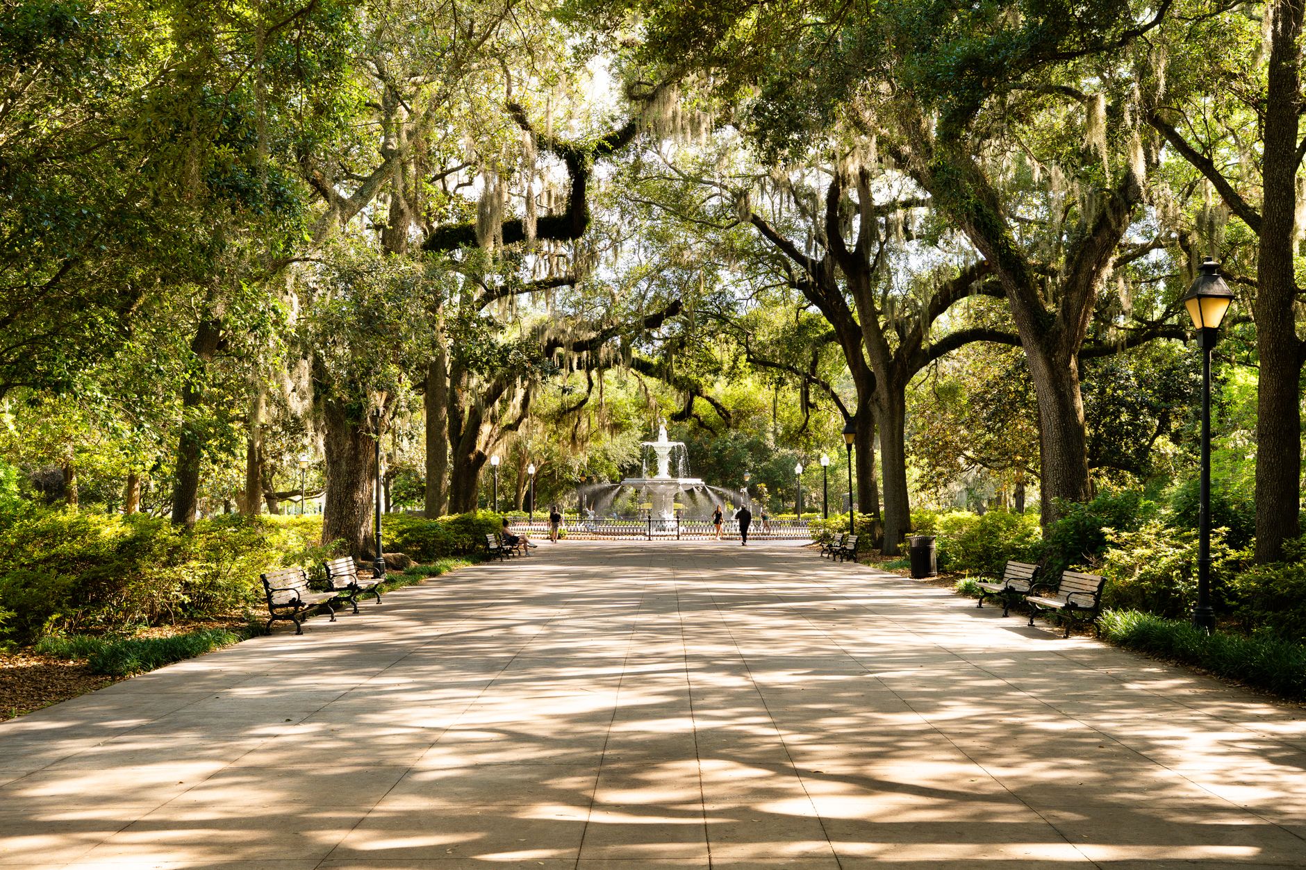 A shaded downtown park square with a central fountain