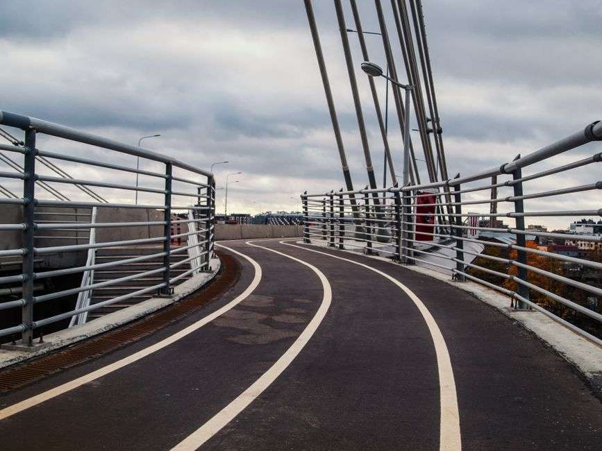A protected bicycle lane runs along a modern bridge span