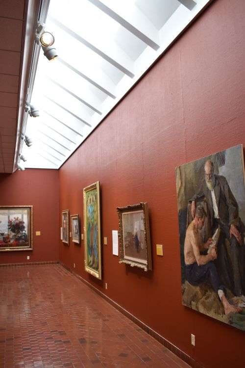 Framed paintings on display in a gallery exhibition space