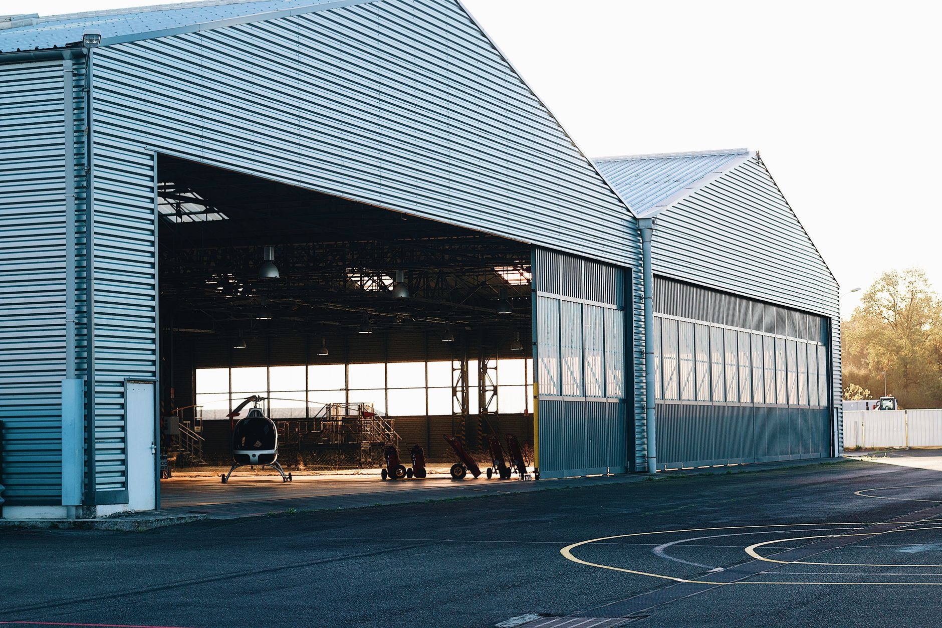 An airfield runway with hangars in the background