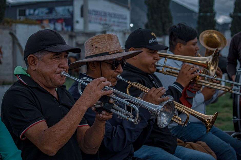 A brass band performs outdoors with trumpets and trombones at a live music event