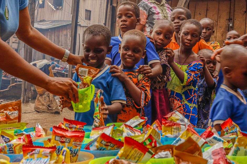 Children receiving care packages from a volunteer in their community