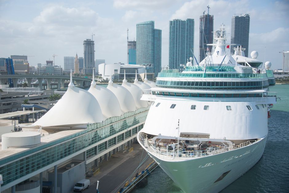 A large cruise ship docked at a city waterfront cruise terminal