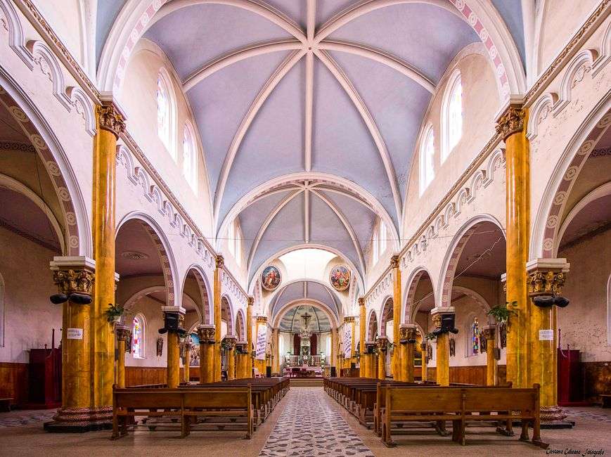 Interior of a Catholic church sanctuary with ornate altar and vaulted ceiling