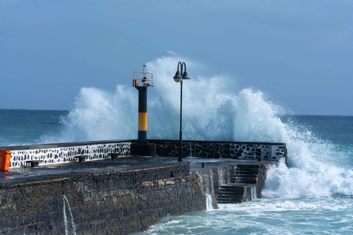 Storm waves crashing against a wooden pier along the Gulf Coast during a tropical storm