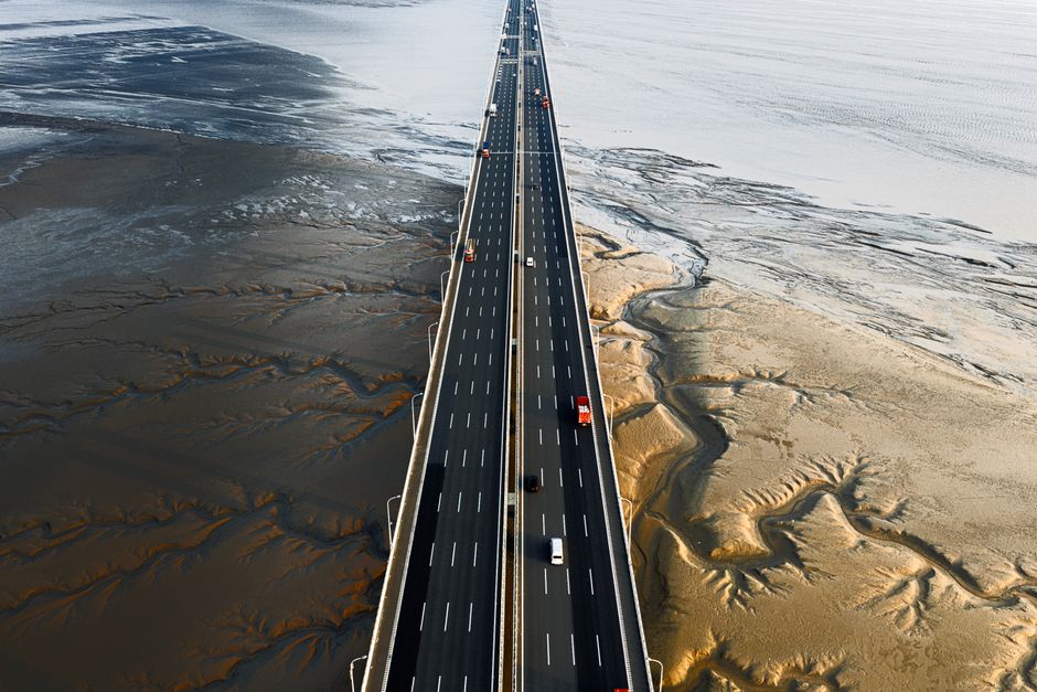 Vehicles crossing a causeway bridge over a bay