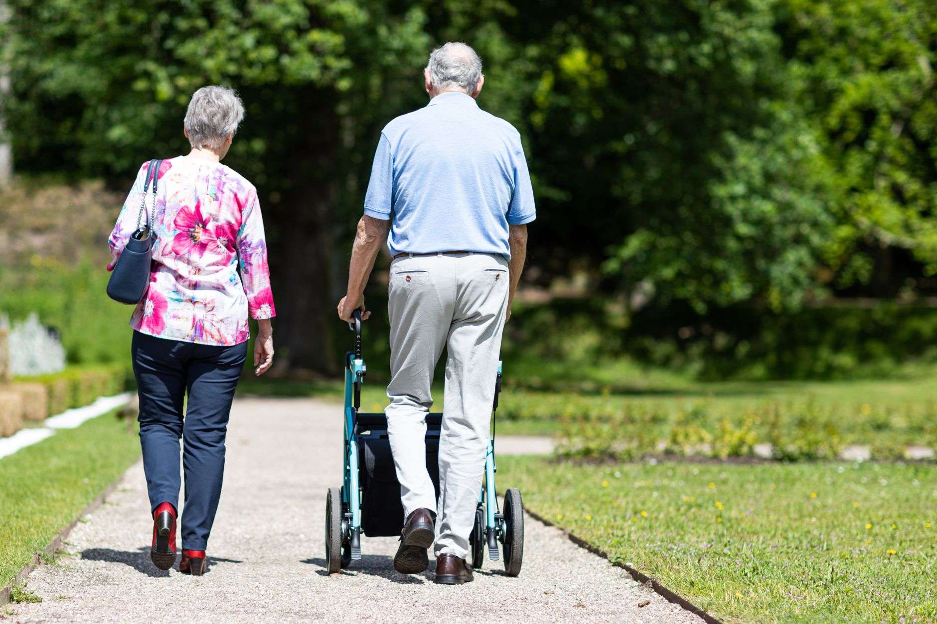 Senior couple walking together outdoors on a paved path