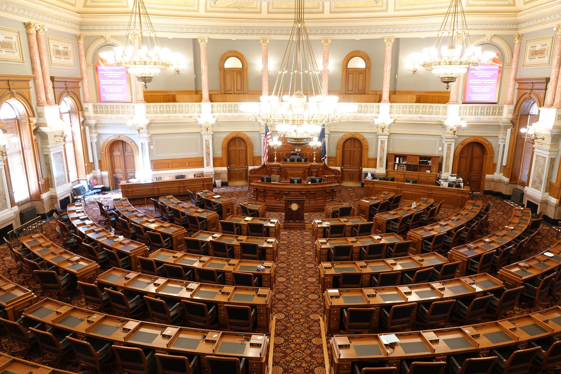 Interior of a state legislative chamber with desks and a rostrum