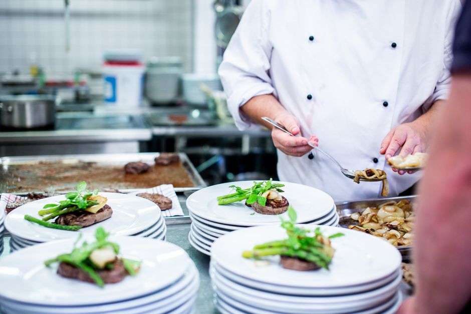 A chef plates a gourmet dish during a culinary competition