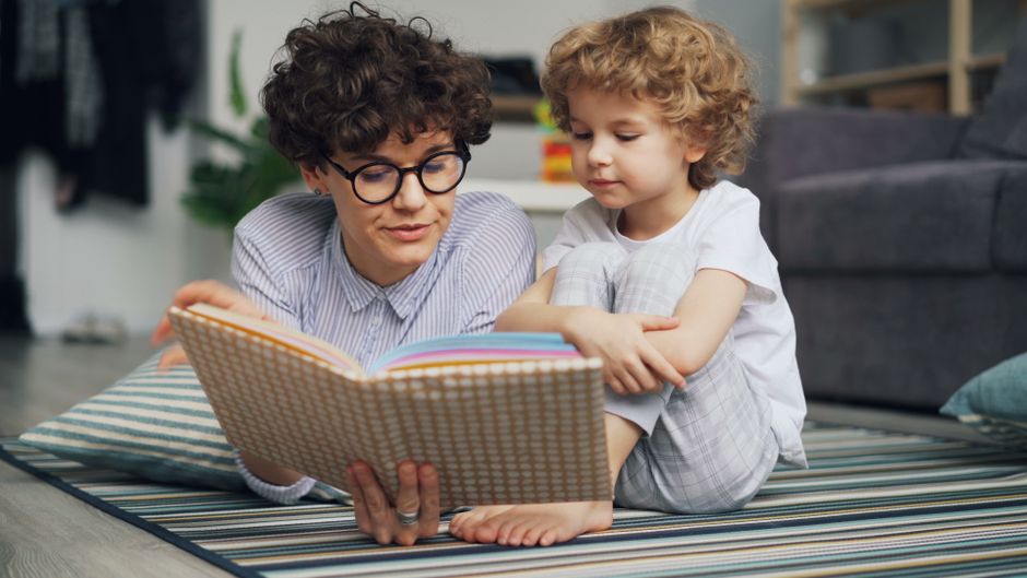 A parent reading a book with a young child