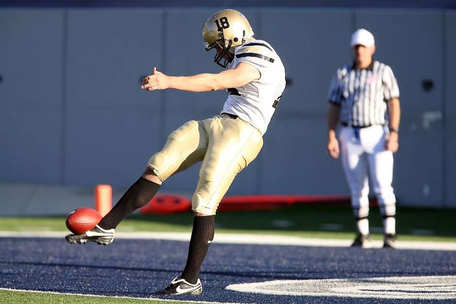 A football player lines up to kick a field goal during a college football game