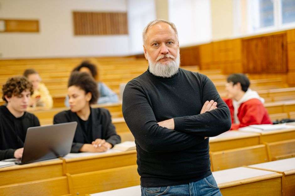 A university professor leads a classroom discussion with students during a statistics lecture