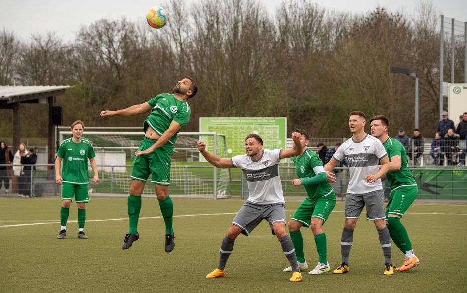 College soccer players compete for the ball during a match on a grass field