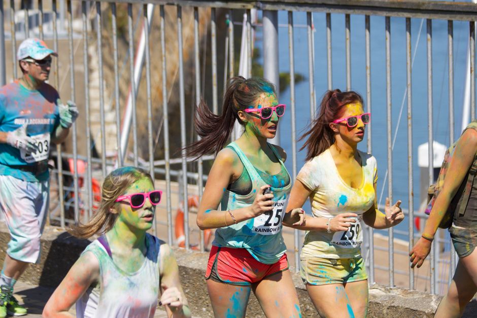Runners covered in colorful powder during a 5K race in downtown Mobile
