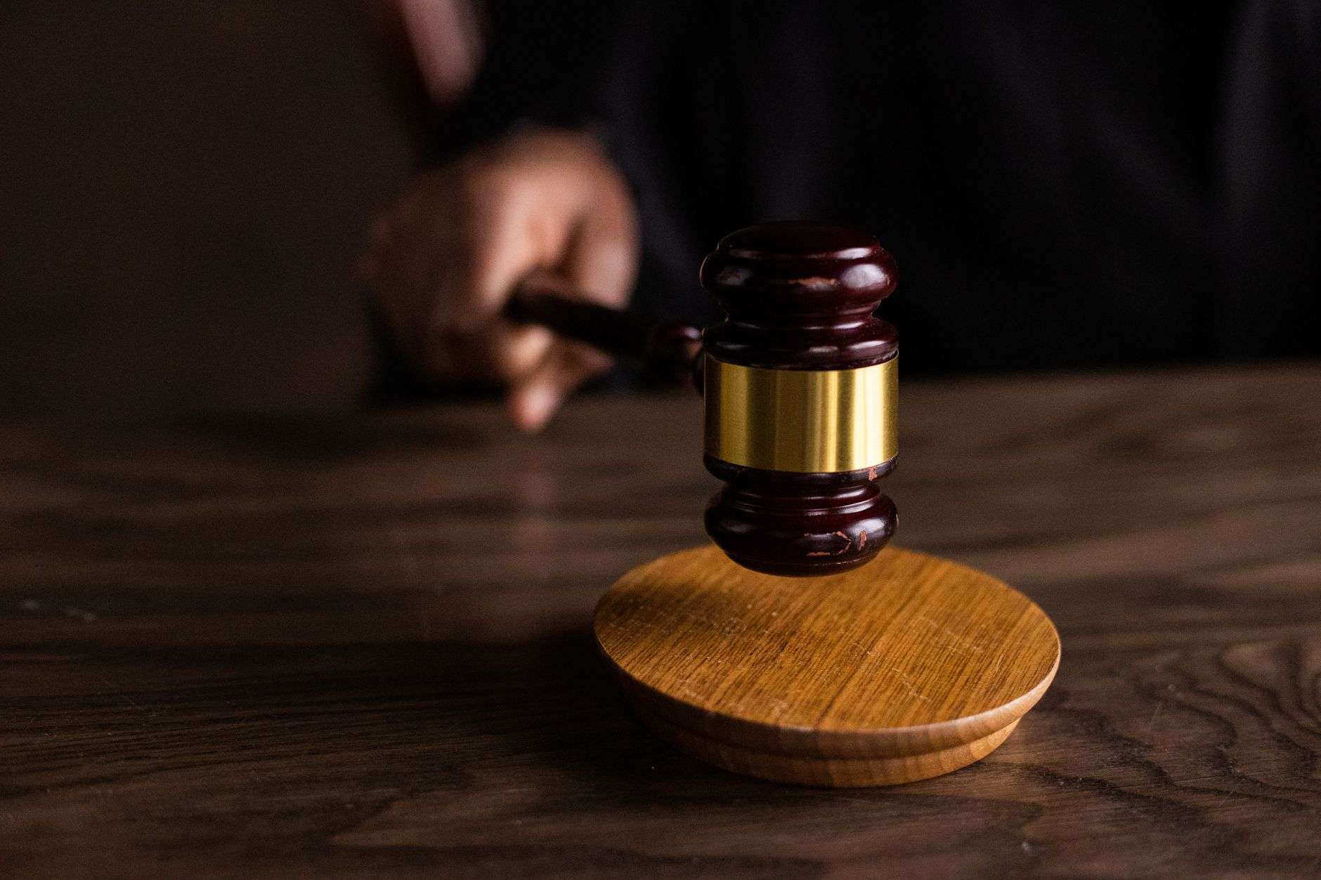 A gavel resting on a sound block in a courtroom setting