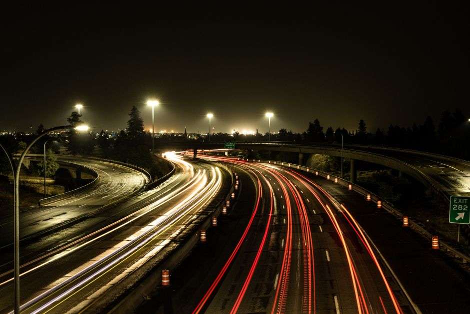 Aerial view of highway light trails at an interstate interchange at night