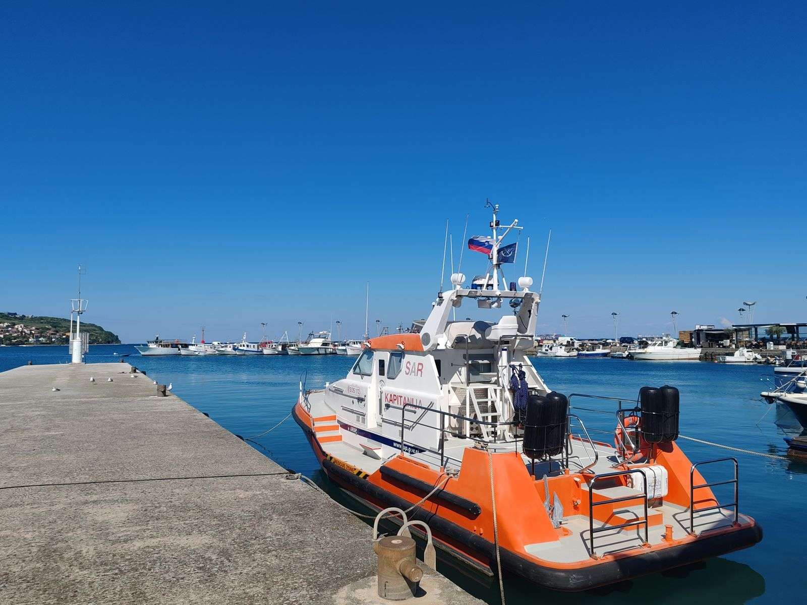 A rescue boat moored at a dock in a marina