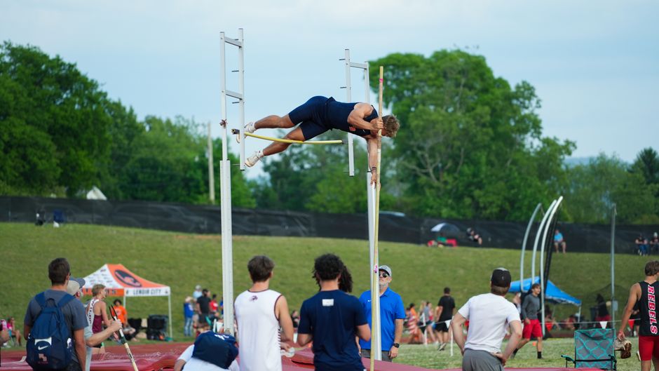 A pole vaulter competing in an outdoor athletic event