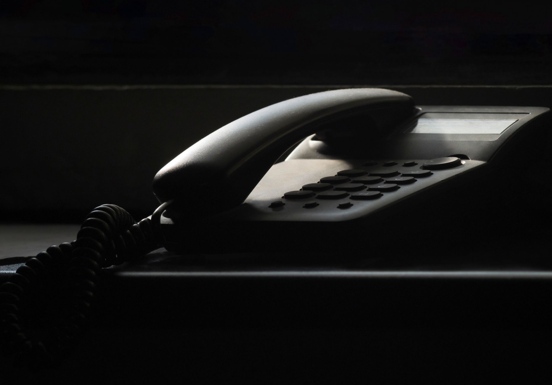 A telephone handset resting on an office desk