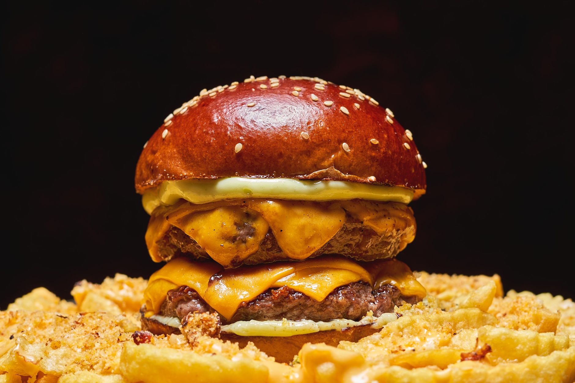 A cheeseburger on a pretzel bun with melted cheese
