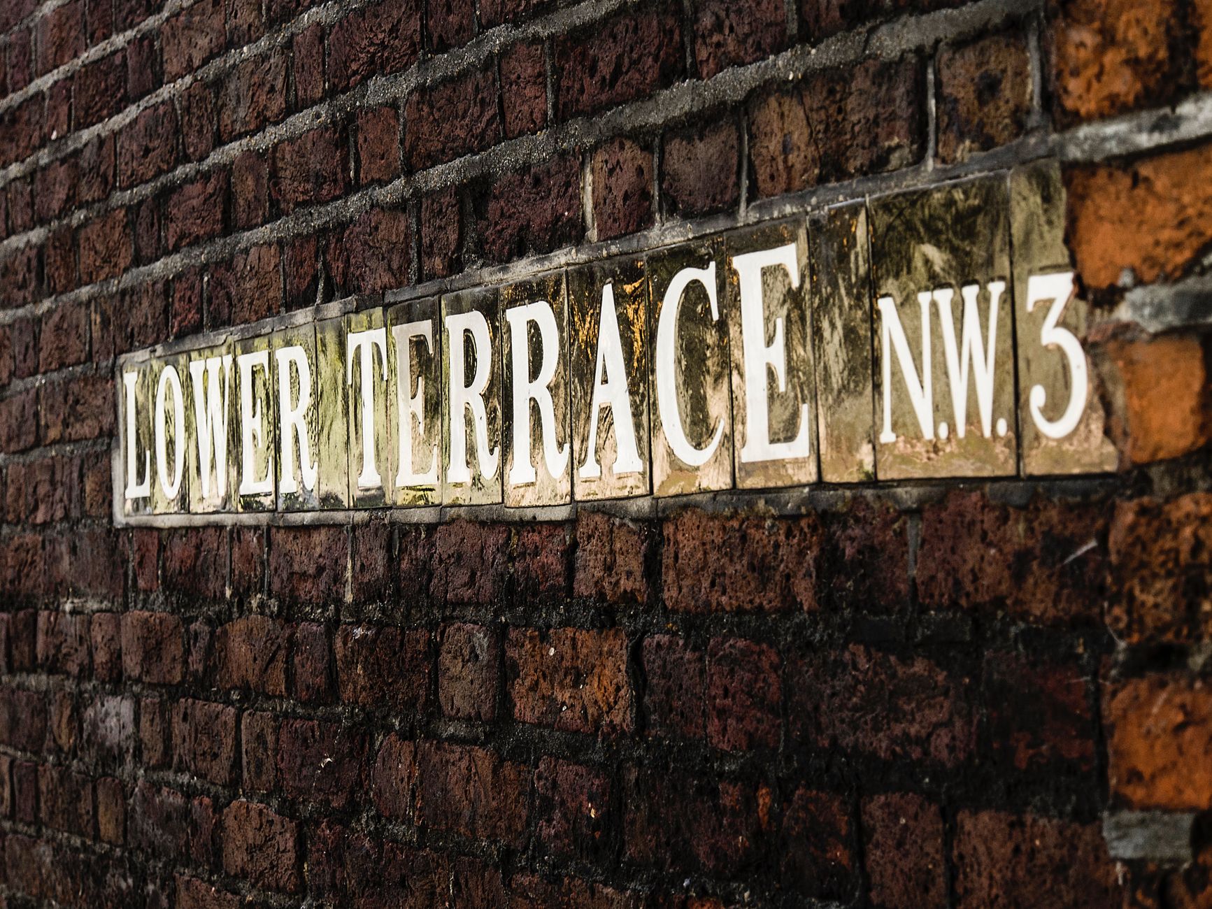 A street name sign mounted on a pole in a historic neighborhood