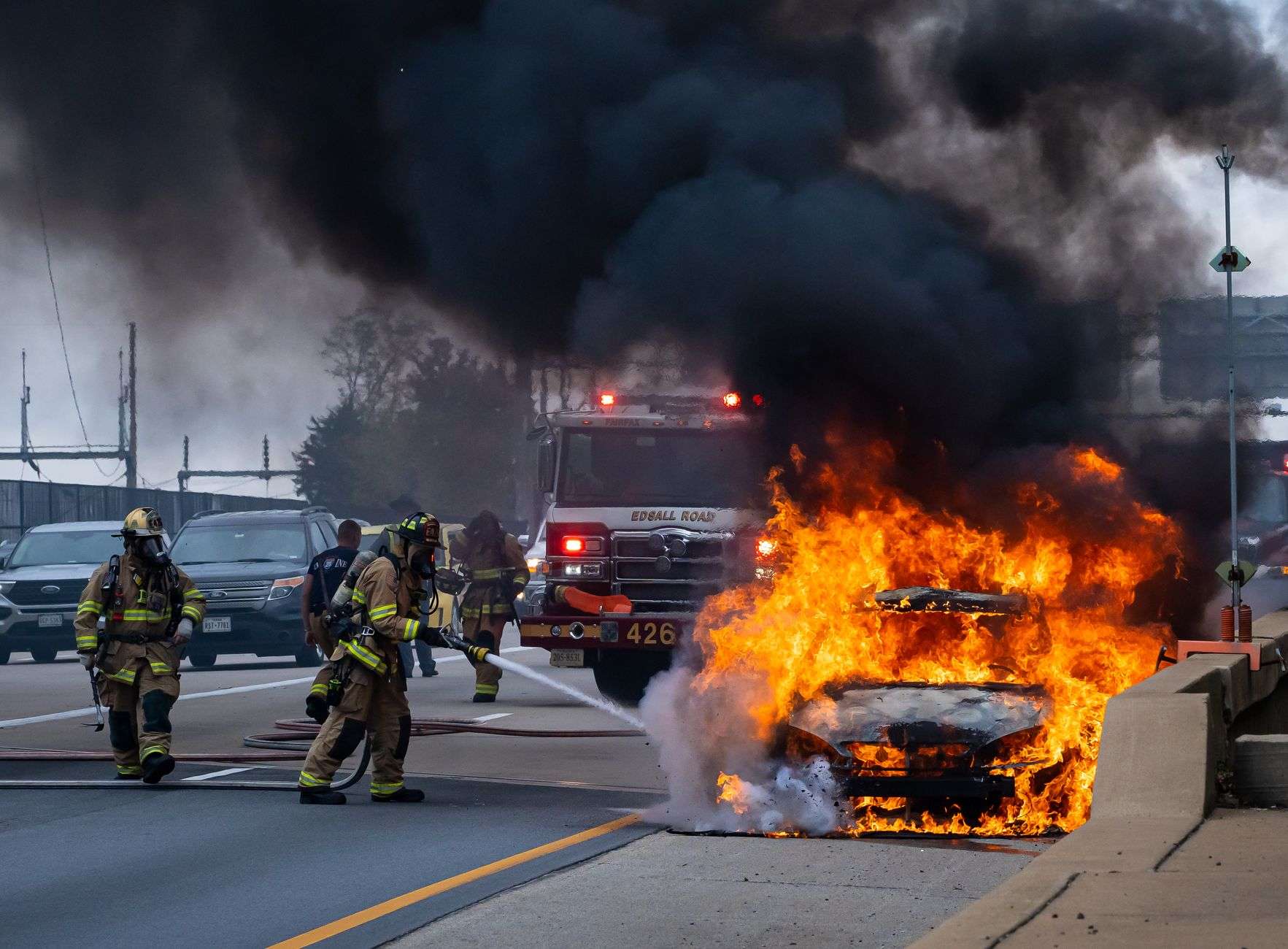 Vehicle fire with smoke on a roadway
